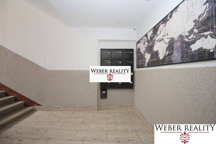 Lépcsőház postaládákkal és világtérképpel, bejárat a kétszobás lakásba.