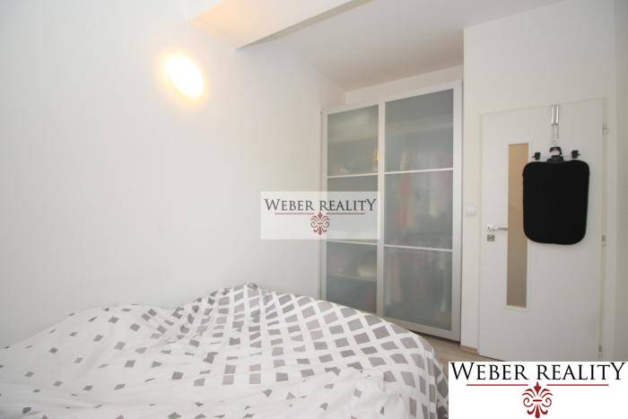 Hálószoba franciaággyal, beépített szekrény, fehér falak a kétszobás lakásban.