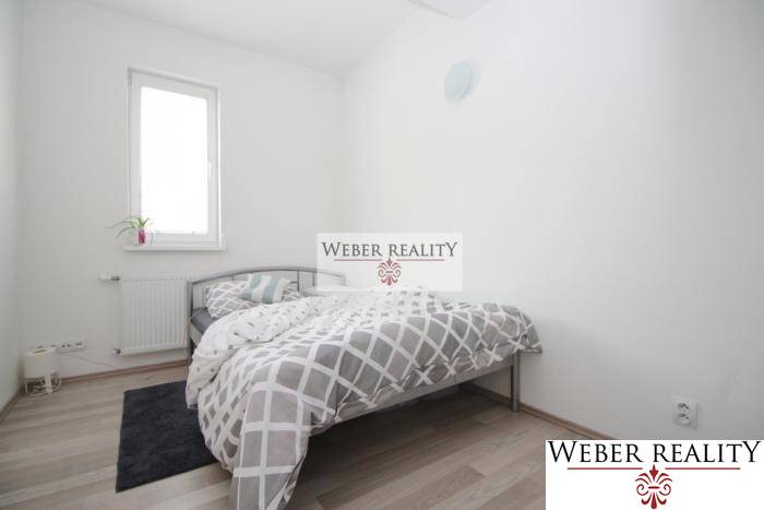 Hálószoba egy kétszobás lakásban, ággyal és fa dekorációjú padlóval.