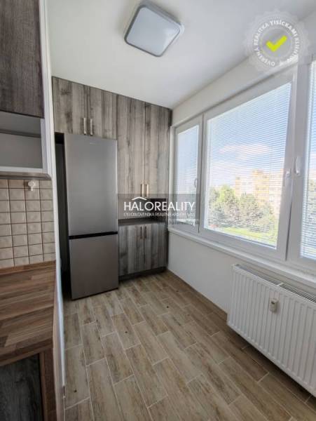 Konyha egy kétszobás lakásban világos fa dekorációjú padlóval és nagy ablakokkal.