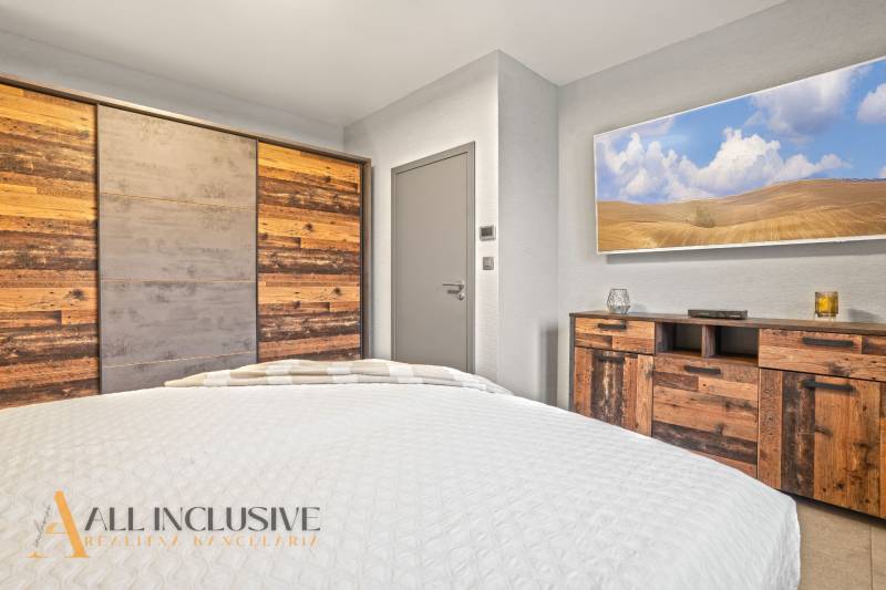 Hálószoba családi házban, bútorokkal és természetes fa dekorral ellátott szekrénnyel.