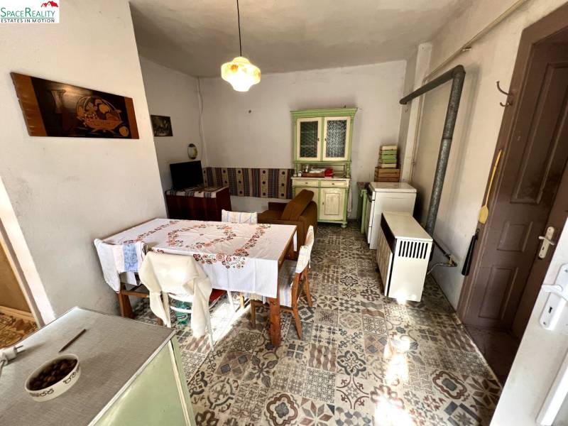 Hagyományos konyha családi házban vintage bútorokkal és díszített padlóval dekorral.