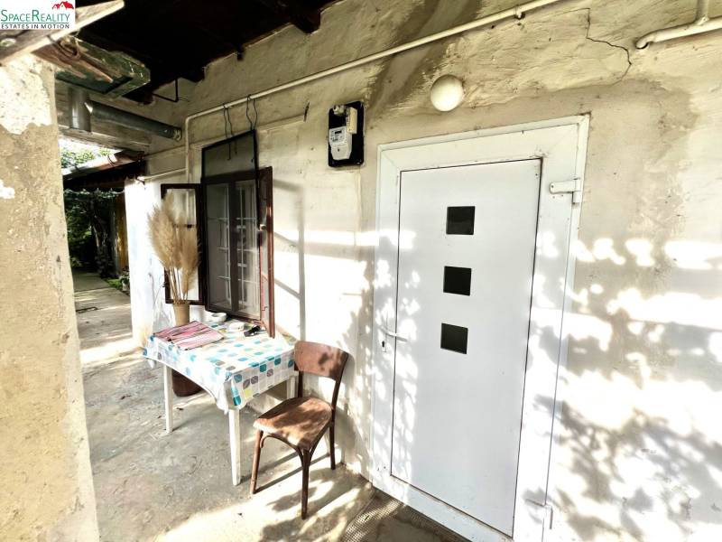 Családi ház Jabloncon, udvarán asztallal és székkel.