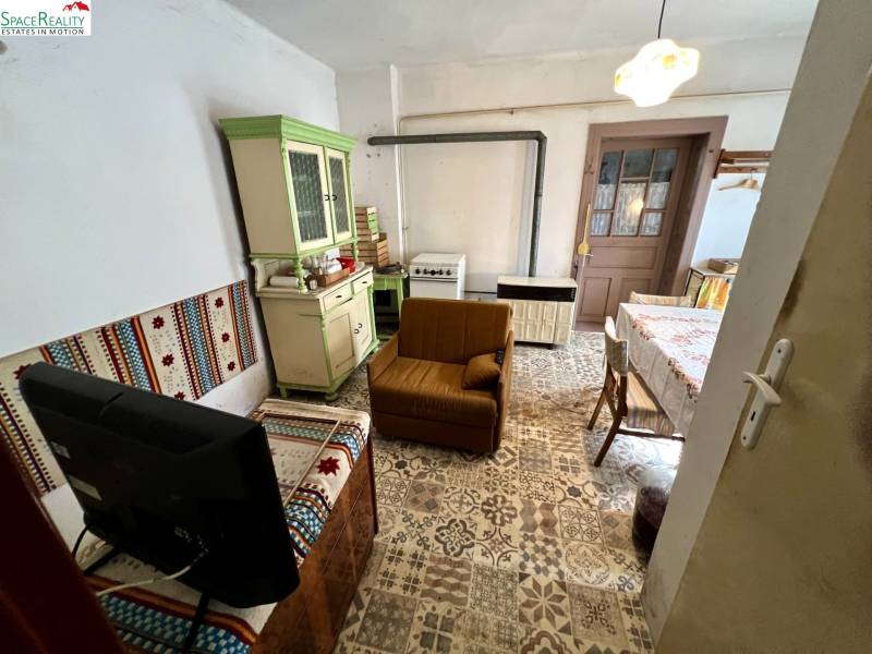 Nappali egy családi házban, rusztikus bútorokkal és mintás padlóval.