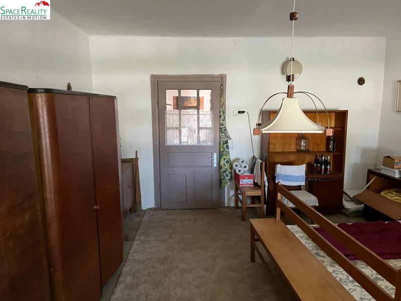 Családi ház belső tere bútorokkal és szőnyeggel, középső lámpa és italpolc.