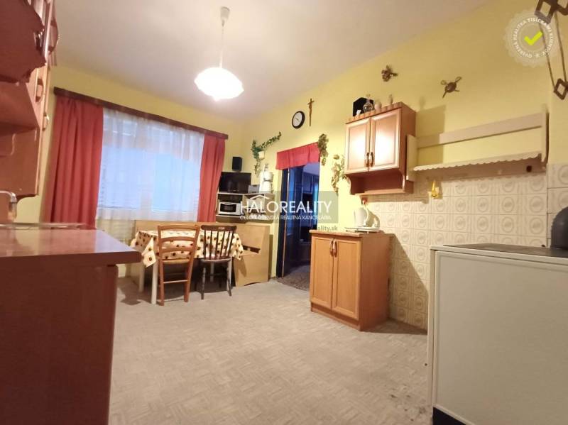 Konyha családi házban fa dekorációval, világos falakkal, asztal székekkel.