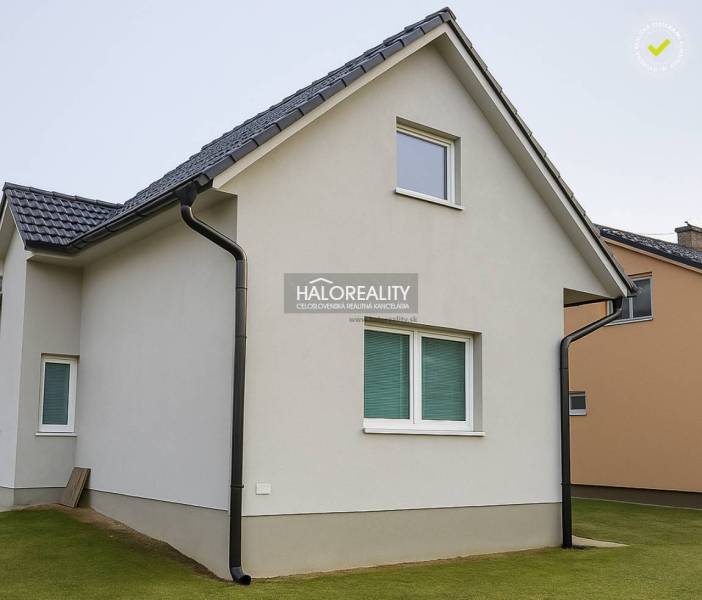 Családi ház Kľačno-ban fehér homlokzattal és ferde tetővel, gondozott gyepen.