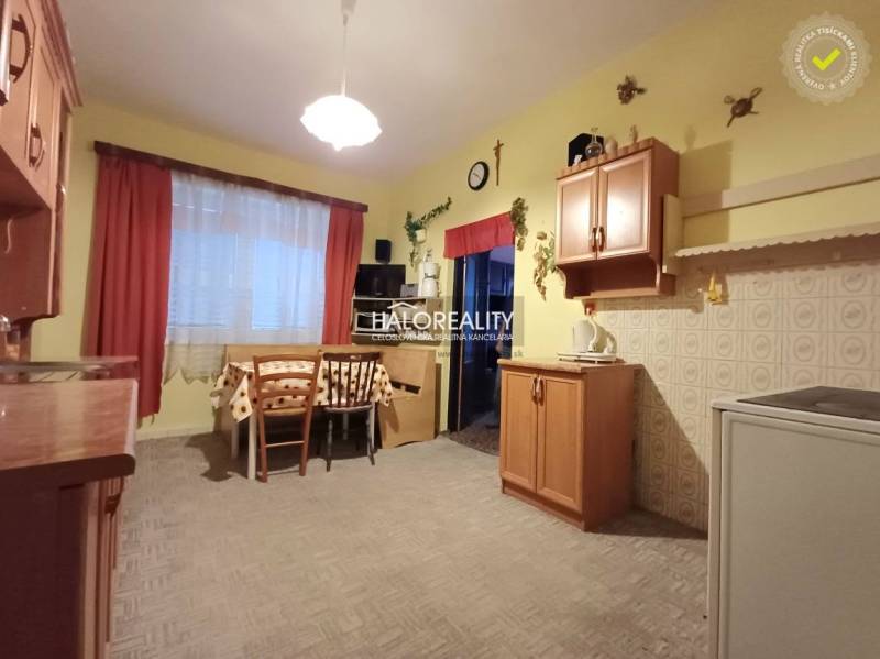 Konyha családi házban fa dekorációval, étkezőasztallal és szekrényekkel.