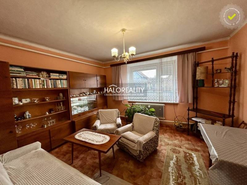 Családi ház nappalija fa dekorációjú bútorokkal és függönyökkel.