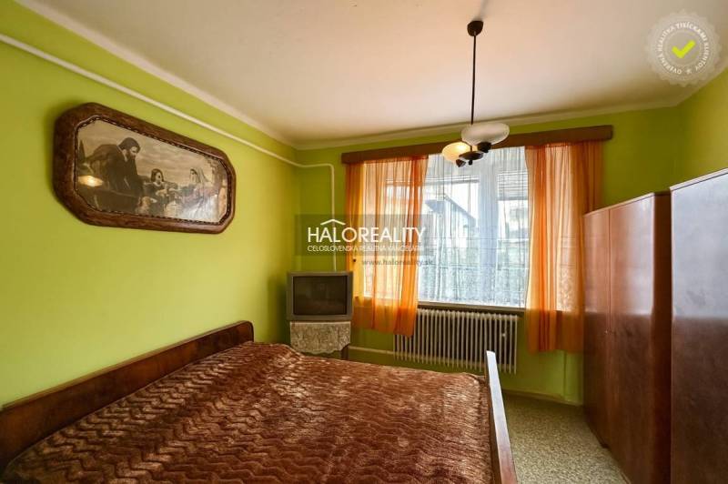 Hálószoba családi házban ággyal, képpel, szekrénnyel és televízióval.