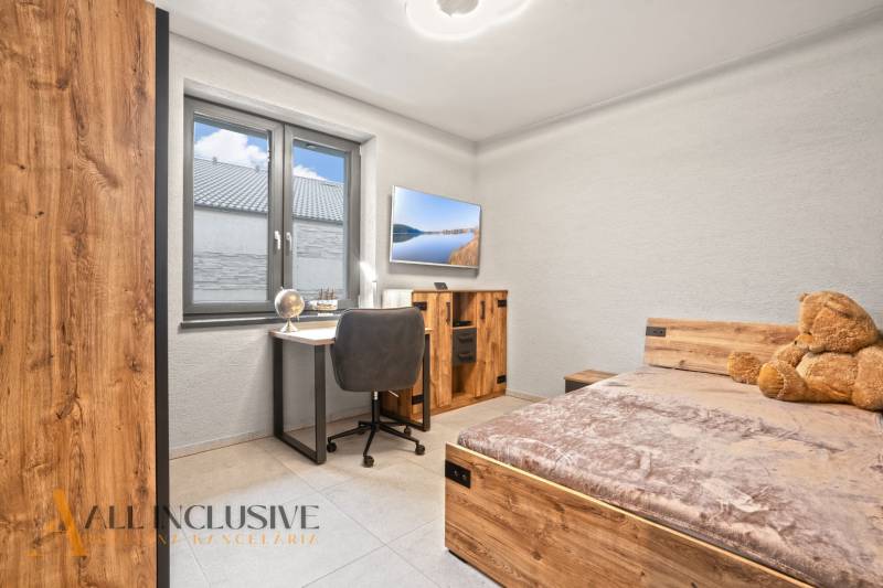 Gyerekszoba egy családi házban, íróasztallal, ággyal és fa dekorációjú padlóval.