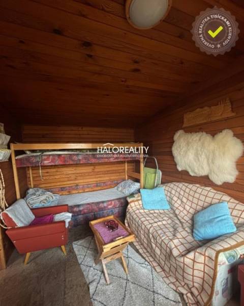 Szoba kanapéval, emeletes ággyal és fa mintázatú padlóval a kertekben.