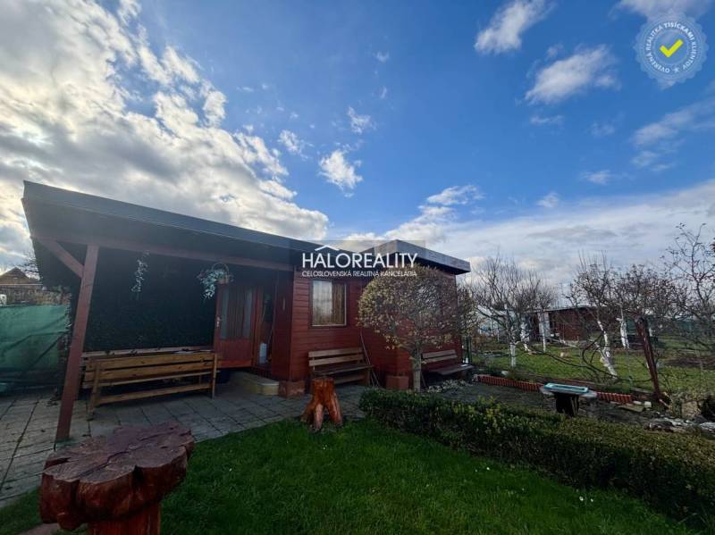 Faházikó a Szepességújhely kertjeiben padokkal és virágágyással.