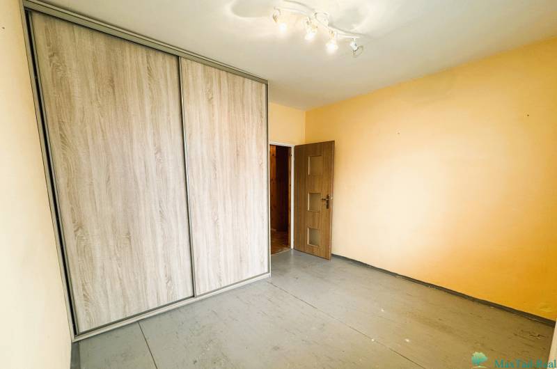 A szoba beépített szekrénnyel és fa dekoros padlóval rendelkezik egy háromszobás lakásban.