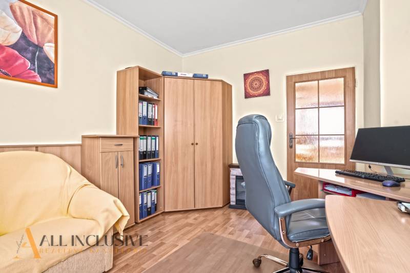 Dolgozószoba egy családi házban irodai székkel és fa mintázatú padlóval.