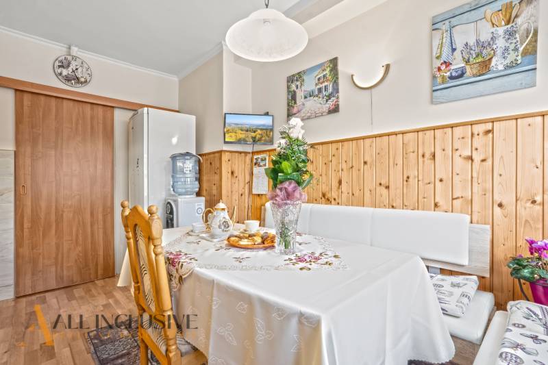 Ebédlő egy családi házban, fa dekorációval, virágdíszítéssel és felszolgált frissítőkkel.