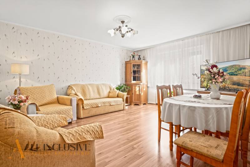 Nappali egy családi házban fa dekoros padlóval és kényelmes bútorokkal.