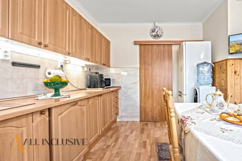 Konyha egy családi házban, fa dekoros padlóval és fa bútorokkal.