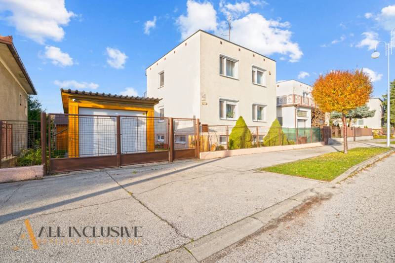 Családi ház Dunaszerdahelyen, előtte rendezett előkert és fémkerítés.