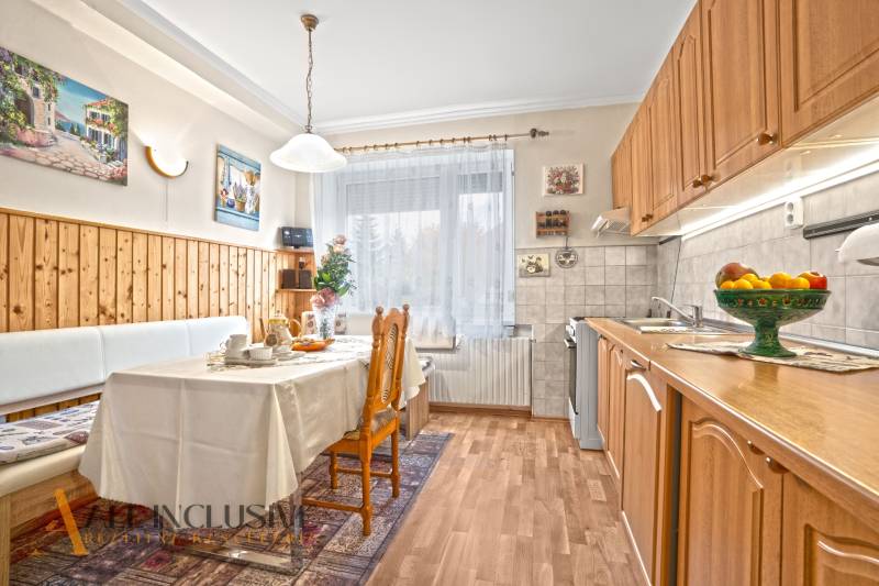 Konyha egy családi házban, fa dekoros padlóval és étkezőasztallal.