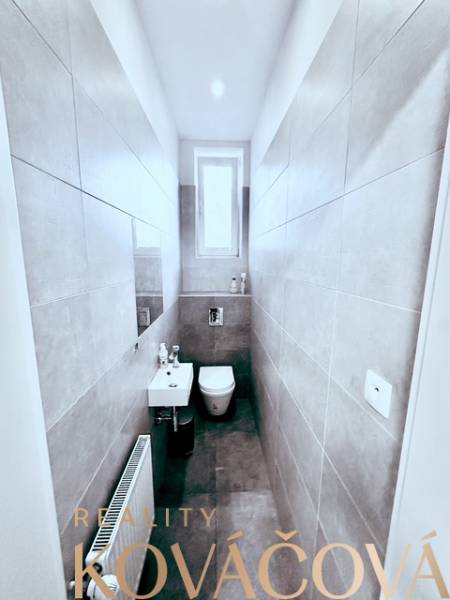 Keskeny WC ablakkal, mosdóval és kerámia csempével. Reality Kováčová irodák.