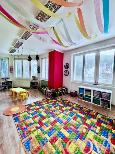Világos térrel rendelkező irodák, fa dekoros padló, gyerek játszószőnyegek, színes dekorációk.