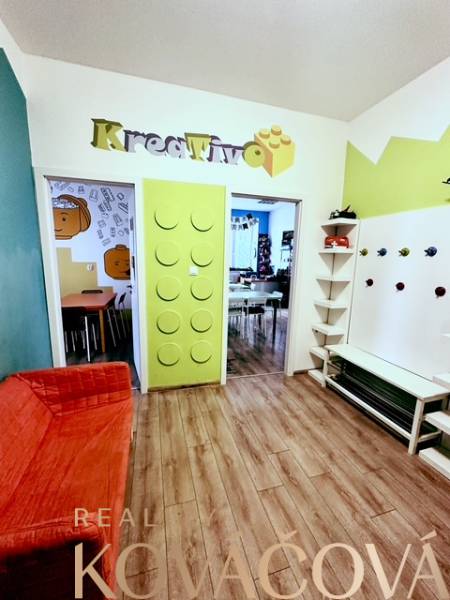 Színes iroda belső tér fa dekor padlóval és kreatív bejárati dizájnnal.