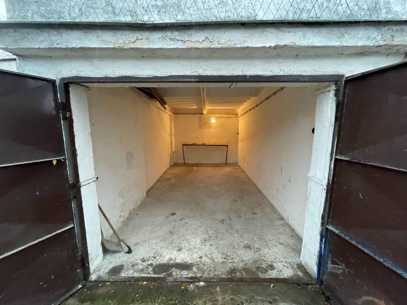 Nyitott garázs a Priekopy-ban, Pozsony-Ružinovban, betonpadlóval és homlokzati asztallal.