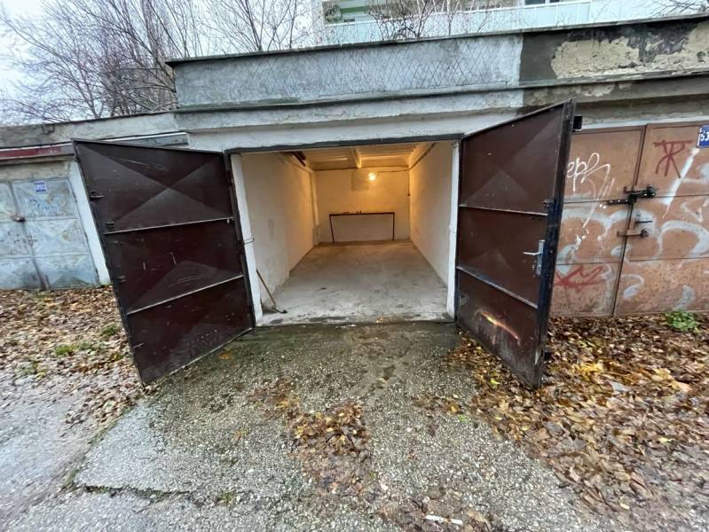 Nyitott garázsok a Priekopy utcában, Pozsony-Ružinovban, őszi levelekkel körülvéve.