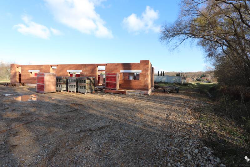 Családi ház építése a Nyitrai Drieňová utcában, félkész téglafalak a természetben.