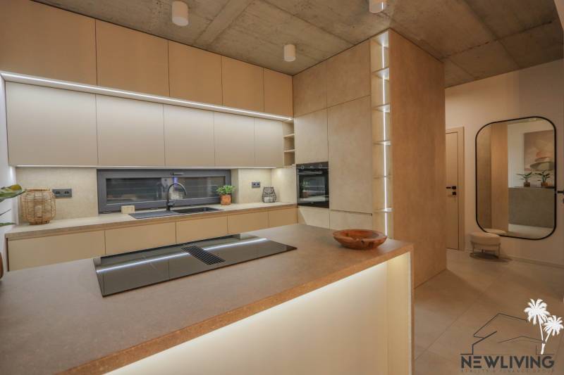 Konyha családi házban beépített készülékekkel, munkalapokkal és fa dekorációjú padlóval.