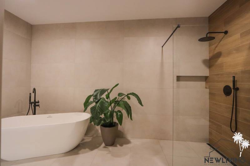 Fürdőszoba családi házban káddal, növénnyel, zuhanyzóval és csempével.