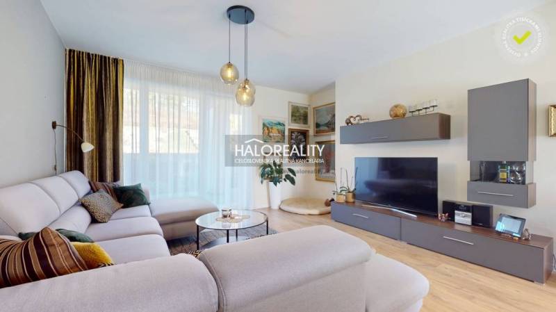 Nappali egy családi házban kényelmes kanapéval és fa dekorációjú padlóval.