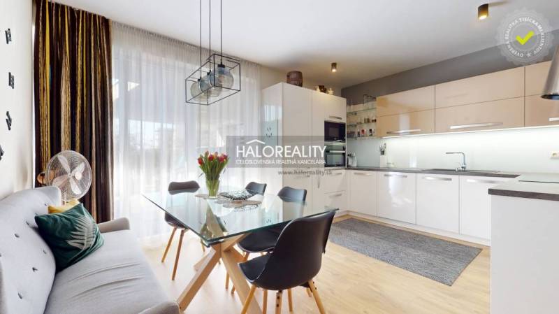 Konyha családi házban étkezőasztallal, kanapéval és fa dekorációjú padlóval.