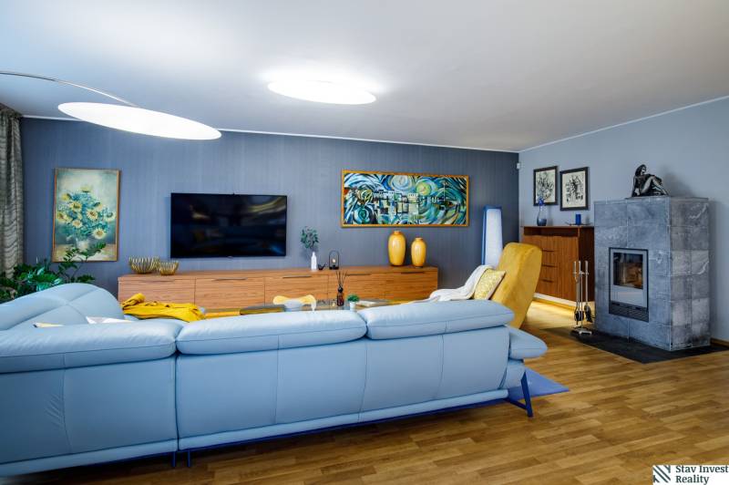 Nappali egy családi házban kandallóval, kanapéval és fa dekorációjú padlóval.