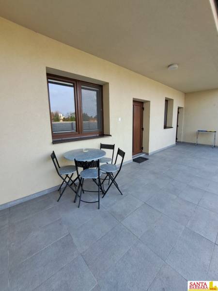 Terasz ülőhellyel egy 4 szobás lakásban, csempézett padlóval és világos falakkal.