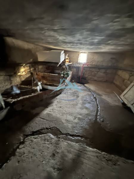 Családi ház pincéje Deménden kőfalakkal és egyszerű világítással.