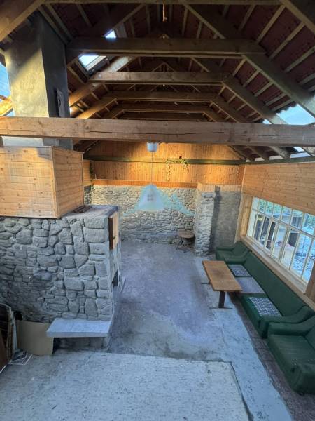 Kőfalak, fa mennyezet és ülőhely egy családi házban.