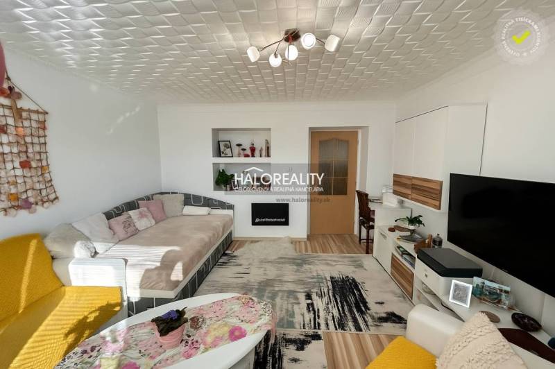 Nappali kényelmes kanapéval egy kétszobás lakásban, fa dekorációjú padlóval.