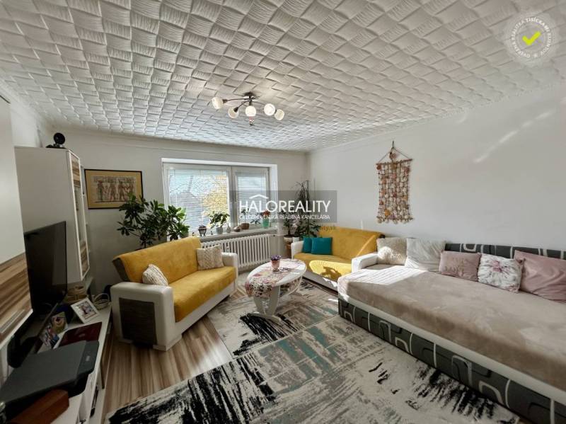 Nappali egy kétszobás lakásban, fa mintázatú padlóval és kényelmes ülőgarnitúrával.