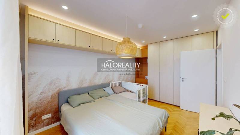 Hálószoba egy háromszobás lakásban beépített szekrényekkel, ággyal és kisággyal.