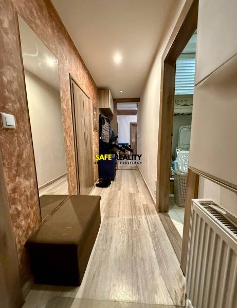 Folyosó egy kétszobás lakásban, fa dekoros padlóval, tükörrel és cipősszekrénnyel.