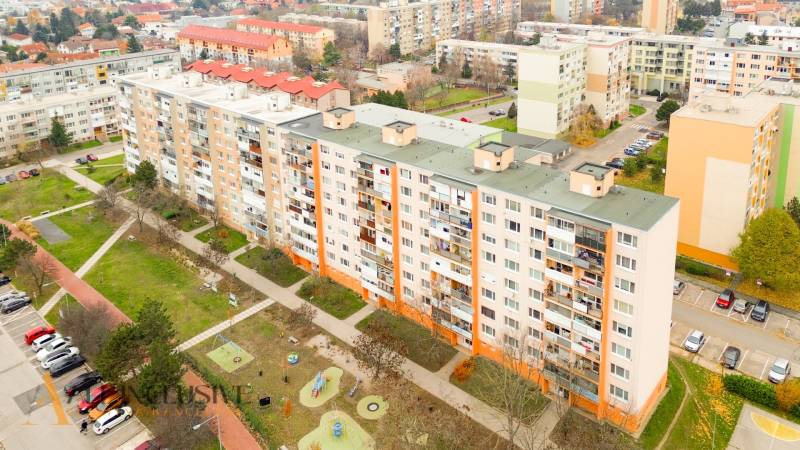 Kilátás a szenci lakótelepre, háromszobás lakásokkal és környező zöldterületekkel.