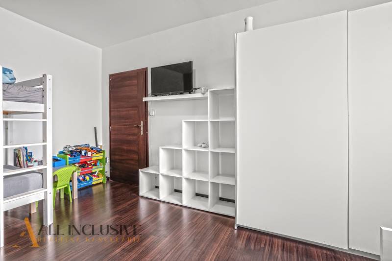 Gyerekszoba emeletes ággyal és tárolóhelyekkel, fa mintázatú padlóval.