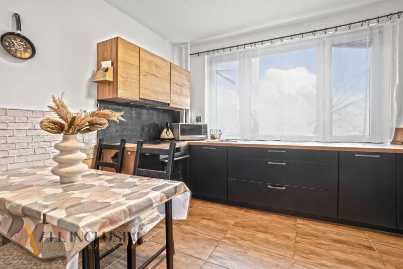 Konyha egy háromszobás lakásban világos dekorációval és fa mintázatú padlóval.