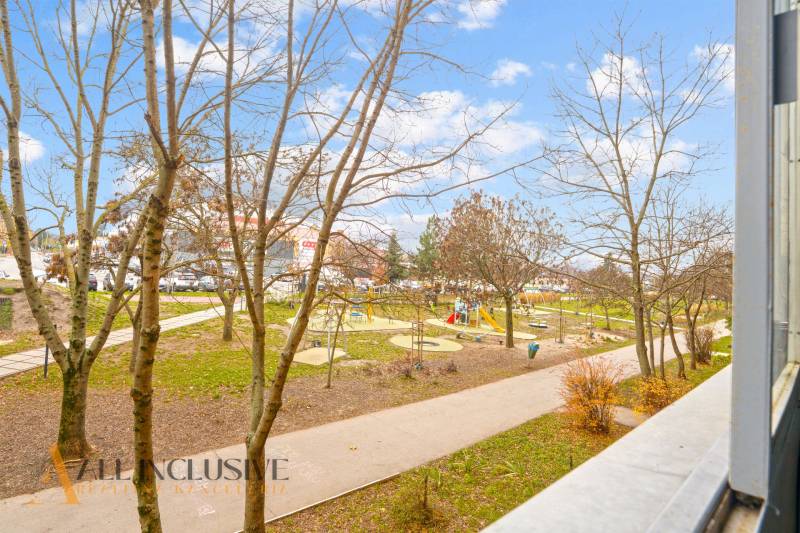 Kilátás egy háromszobás lakásból Szencen egy parkra játszótérrel.