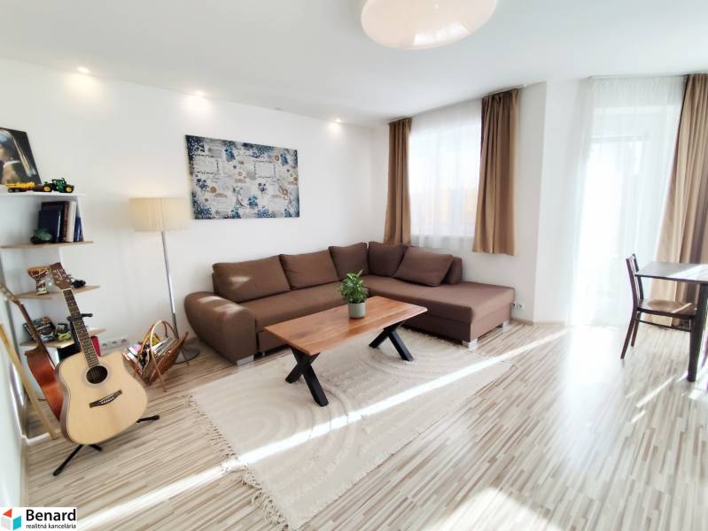 Nappali egy családi házban nagy kanapéval és fa dekorációjú padlóval.