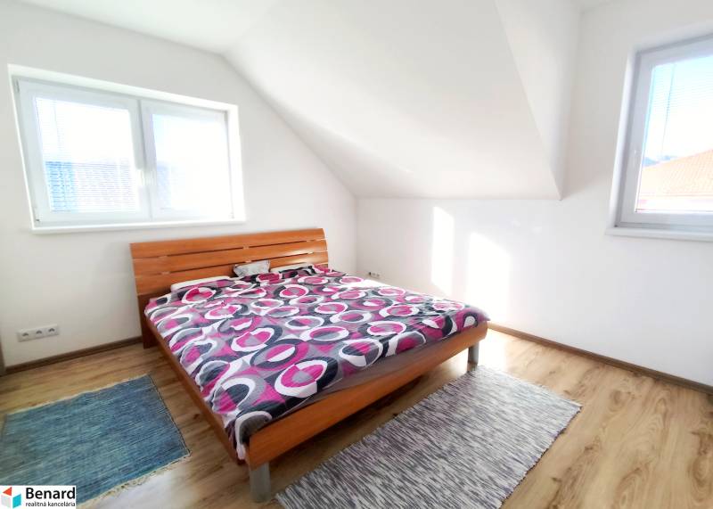 Hálószoba ággyal és fa dekorációjú padlóval egy családi házban.