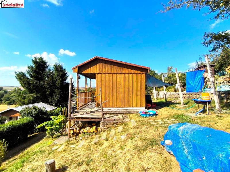 Faház Partizánskomban, amelyet természet vesz körül, füves területtel és kinti ülőhellyel.