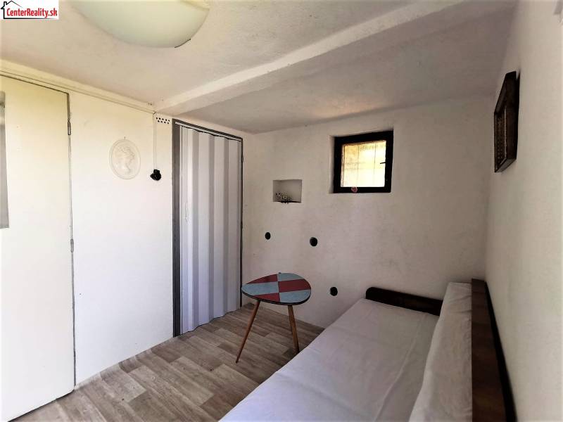 A ház egy hangulatos szobát tartalmaz kanapéval, asztallal és fa padlóval.